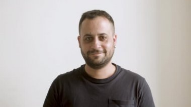 Neşeli sakallı adam kameraya bakıyor..