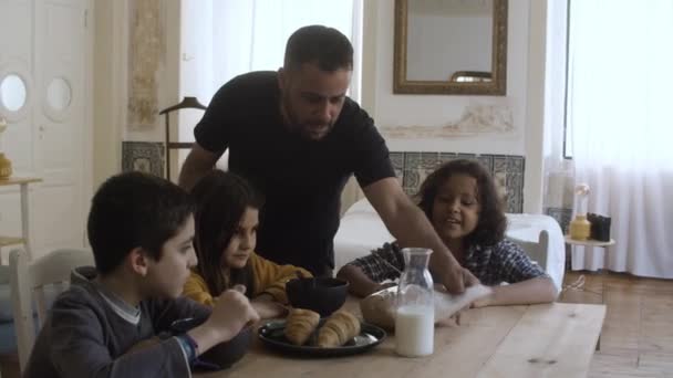 Padre soltero vertiendo cereal en los platos de los niños en el desayuno. — Vídeos de Stock