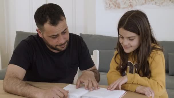 Кавказький батько допомагає дочці виконувати домашні завдання.. — стокове відео