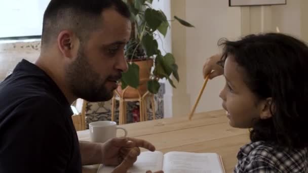 Pai feliz ajudando seu filho com lição de casa em casa — Vídeo de Stock