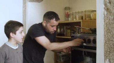 Oğlu beyaz bir baba kahvaltı için yemek hazırlıyor..