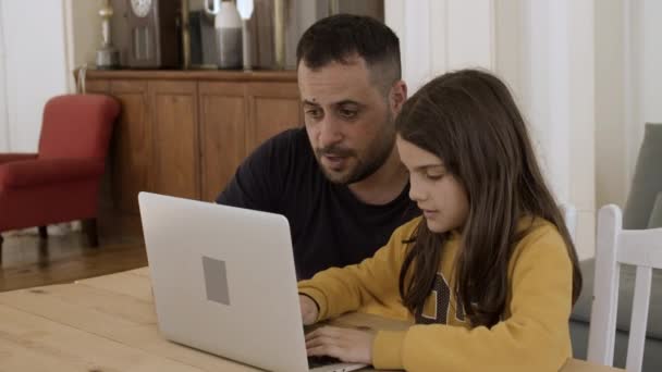 Caucasiano pai e filha sentados à mesa, usando laptop. — Vídeo de Stock