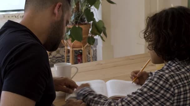 Visão traseira do pai solteiro com o filho fazendo lição de casa em casa. — Vídeo de Stock