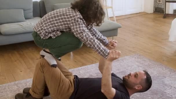 Glücklich Papa spielt mit seinem Sohn auf dem Fußboden zu Hause. — Stockvideo