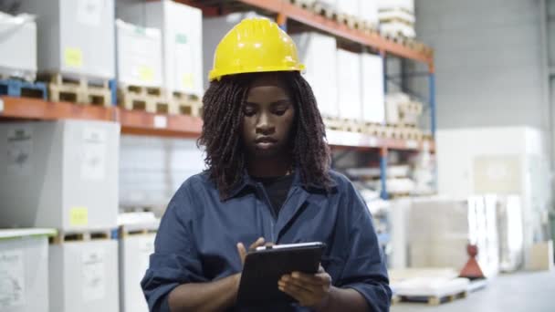 Trabajadora afroamericana enfocada trabajando en almacén. — Vídeos de Stock