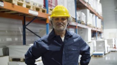 Depoda duran miğferli kıdemli işçi.