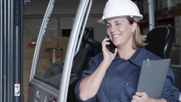 Usmívající se zaměstnankyně doručovatelské společnosti hovořící po telefonu. — Stock video