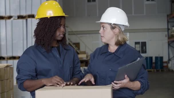 Vidám, változatos női munkások beszélgetnek a raktárban. — Stock videók