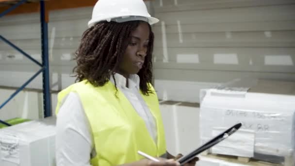 Side view of focused female worker going in warehouse. — Αρχείο Βίντεο