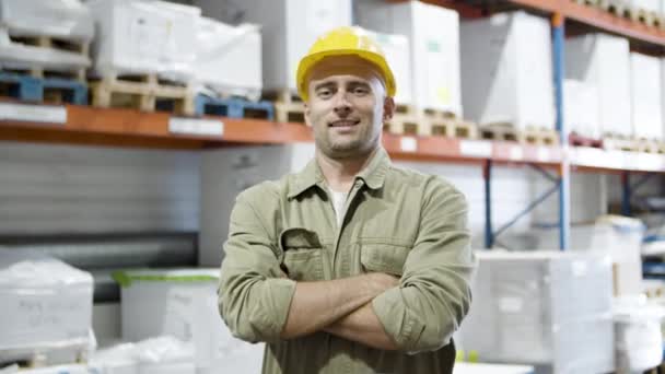 Smiling male worker standing and crossing arms in warehouse. — Stock Video
