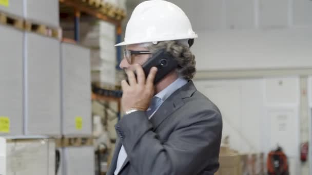 Gericht supervisor in bril praten over de telefoon in de fabriek. — Stockvideo