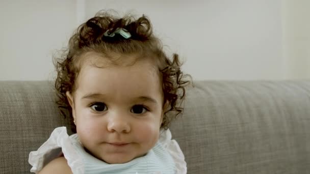 Primer plano de lindo niño sentado en el sofá, mirando a la cámara. — Vídeos de Stock
