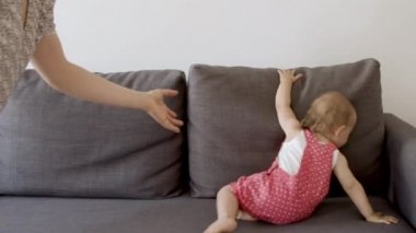 Neşeli kız kanepede yürüyor ve oturuyor..