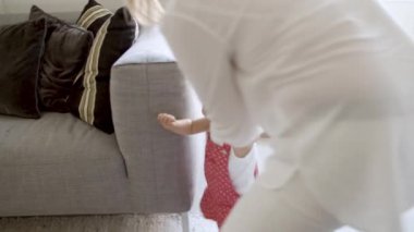 Heyecanlı küçük kız annesinin yardımıyla ilk adımlarını atıyor..