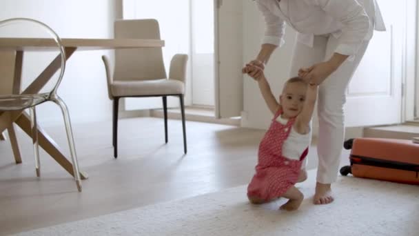 Schattig lachend baby meisje proberen om haar eerste stappen te doen. — Stockvideo