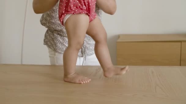 Primer plano de las piernas de las niñas haciendo esfuerzos para dar los primeros pasos. — Vídeos de Stock