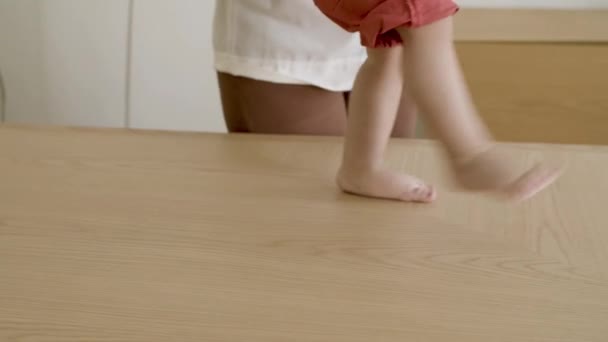 Çıplak ayaklı küçük oğlanların bacakları masada yürürken.. — Stok video