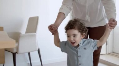 Gülümseyen çocuğun yürüdüğü ve annelerinin elini tuttuğu ön manzara..