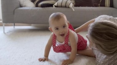 Kafkasyalı anne ve bebek yerde eğleniyorlar..