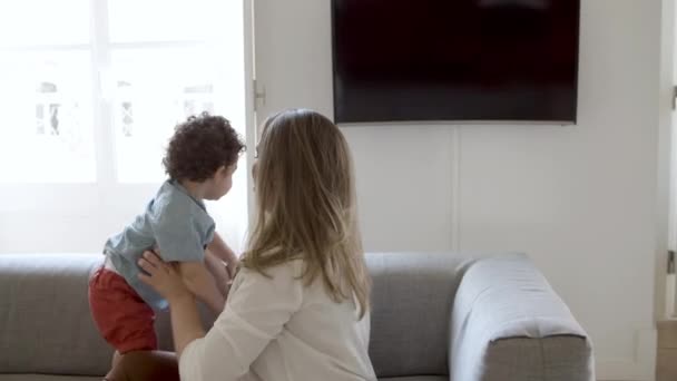 Mãe feliz deitada no sofá e brincando com seu filho. — Vídeo de Stock