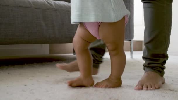 Primer plano de las niñas descalzas piernas caminando en la alfombra con mamá. — Vídeos de Stock