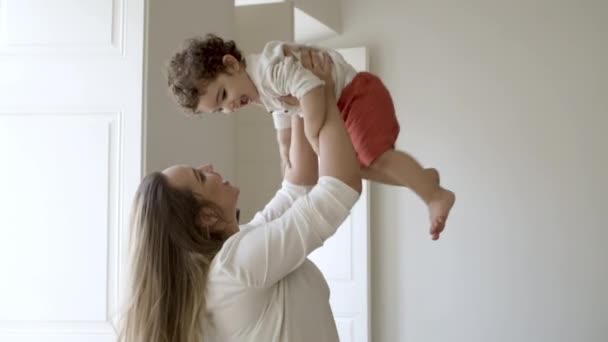 Szczęśliwa samotna matka stojąca i podnosząca swojego synka. — Wideo stockowe