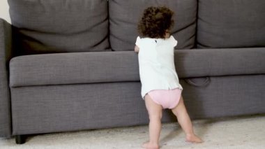 Kanepenin yanında duran küçük kızın arkası..