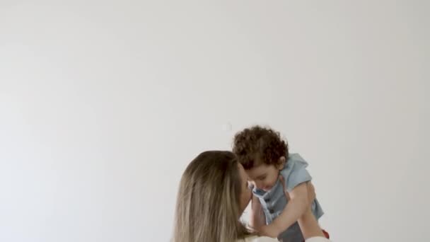 Счастливая мама воспитывает своего маленького сына над головой. — стоковое видео