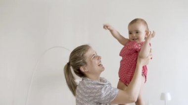 Mutlu anne kızını elinde tutuyor, onunla oynuyor.. 