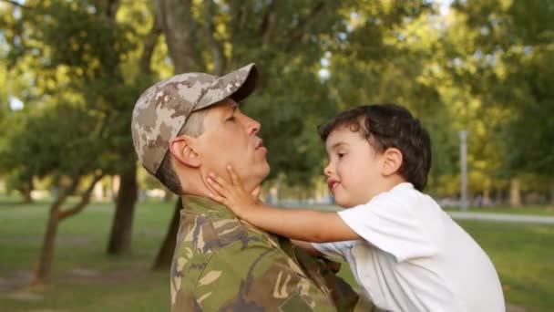 Stark militär pappa håller lille son i vapen — Stockvideo