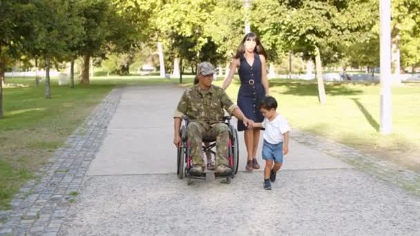 Άτομα με ειδικές ανάγκες πρώην στρατιωτικός που περπατά με την οικογένεια στο πάρκο — Αρχείο Βίντεο