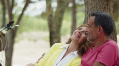 Park bankında oturan yaşlı çiftin orta boy fotoğrafı.