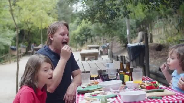 Longue photo de la famille à table dans la forêt d'été — Video