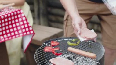 Hamburger köftelerini ızgaraya koyan adamın dikey hareketi