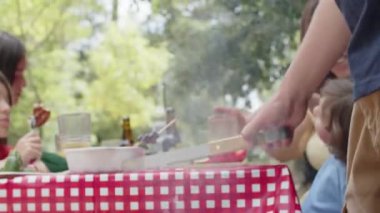 Erkeklerin el yapımı, metal diller kullanarak et pişirmelerinin yakın çekimi.