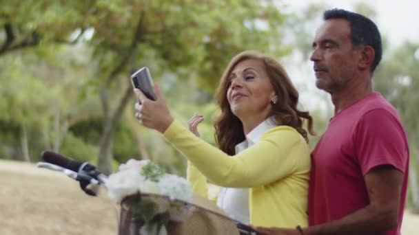 快乐的白种人夫妇看着相机，拿着自己的手机 — 图库视频影像