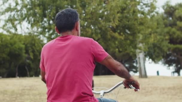 Vue arrière de l'homme âgé à vélo dans le parc — Video