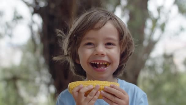 幸せな男の子のクローズアップ食べるトウモロコシのコブ — ストック動画