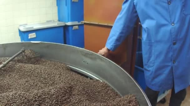 Male worker opening valve to empty coffee beans from machine — Stock Video