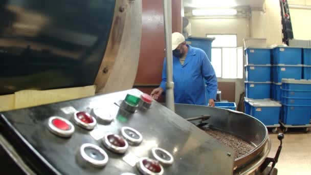 Slider shot of worker standing next to spinning machine — Stock Video
