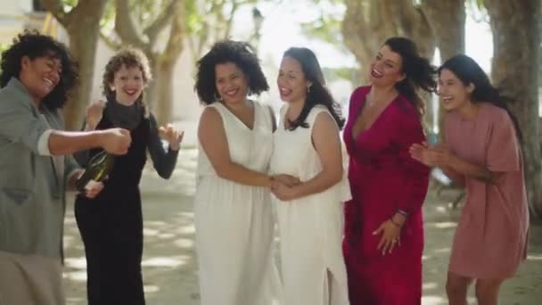 Bruidsmeisje opening fles champagne op lesbische bruiloft — Stockvideo