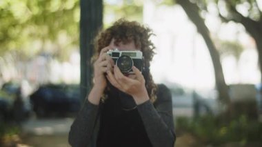 Yaz parkında çalışan genç fotoğrafçının ön görüntüsü.
