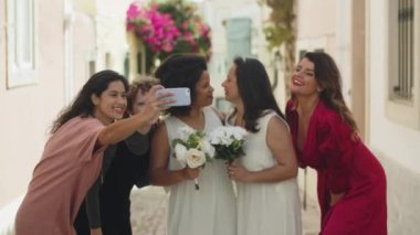 Lezbiyen gelinlerin arkadaşlarıyla fotoğraf çektiği orta boy bir fotoğraf.