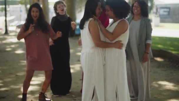 Glückliche Bräute tanzen mit Gästen im Sommerpark — Stockvideo