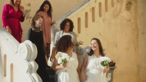 Feliz pareja femenina con amigos después de la ceremonia de boda — Vídeo de stock