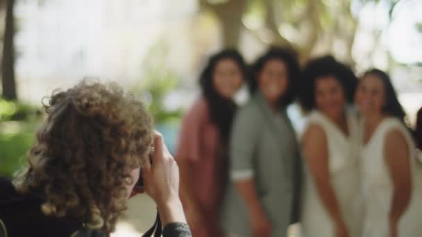 Visão traseira do fotógrafo tirando foto de recém-casados com amigos — Vídeo de Stock
