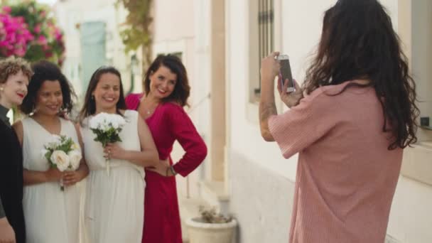 Düğünde arkadaşlarıyla lezbiyen çiftin fotoğrafını çeken bir kız. — Stok video