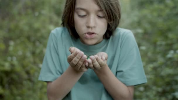 Colpo medio di ragazzo che tiene le pietre sui palmi delle mani e parla incantesimo — Video Stock