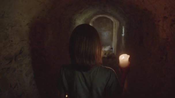 Vista trasera del niño pasando por un túnel oscuro y mirando hacia atrás — Vídeo de stock
