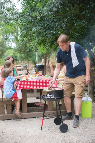 Mangal yapan mutlu babanın portresi.